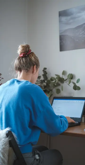 The girl works at home at the laptop